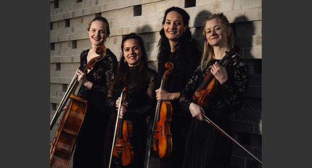 Das Elaia Quartett steht vor einer Wand mit ihren Instrumenten in der Hand