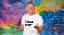 Michl Müller im weißen T-Shirt mit Aufdruck "Dreggsagg" vor einer Graffiti-Wand