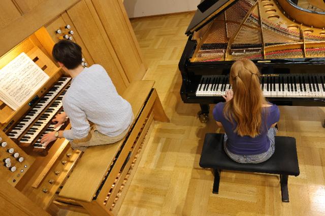 Schüler sitzen an Orgel und Klavier