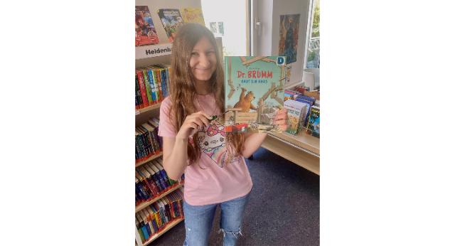 Eien Frau hält das Buch Dr. Brumm hoch