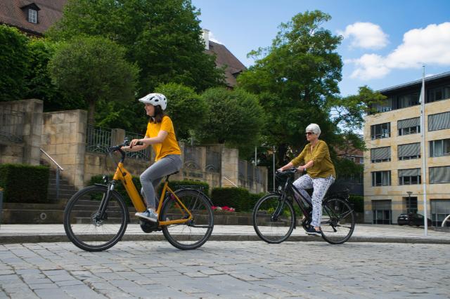 Zwei Frauen fahren auf dem Fahrrad durch die Opernstraße in Bayreuth