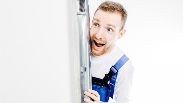 Orgelbauer Fröhlich hinter einer Orgelpfeife