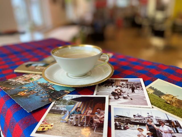 Kaffeetasse auf gedecktem Tisch  mit vielen alten Fotos