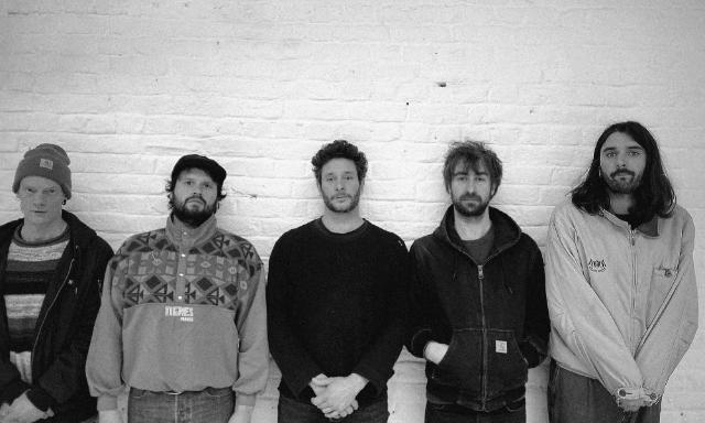 die Mitglieder von Druugg stehen aufgereiht nebeneinander und schauen in die Kamera