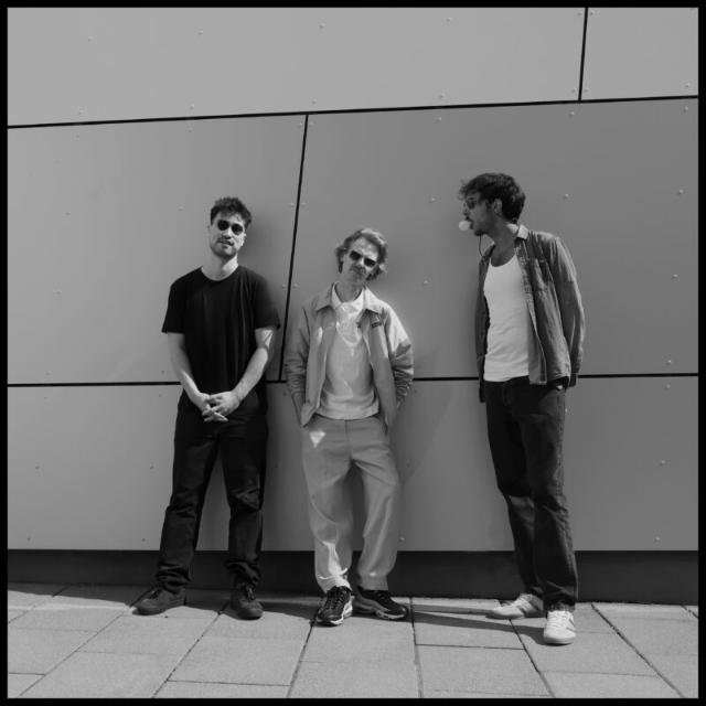 Die Band lehnt an einer Mauer