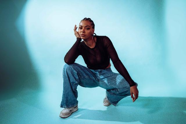 Foto einer jungen Frau vor blauem Hintergrund.