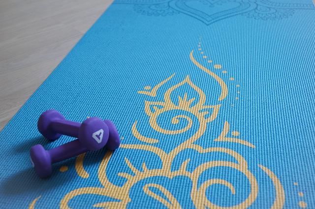 Yogamatte mit Hanteln darauf liegend. 