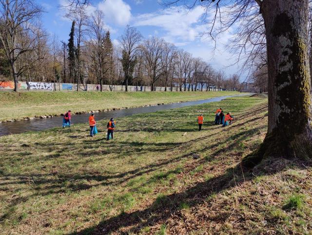 Menschen sammeln am Ufer des Roten Mains Müll
