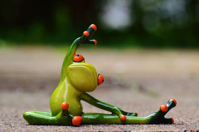 Eine Froschfigur trainiert Yoga