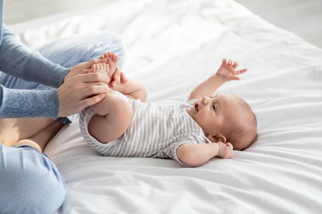 Ein Baby wird an den Füßen massiert