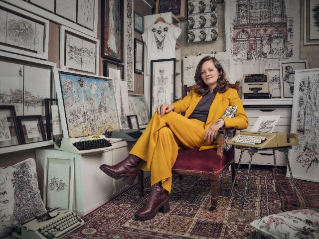 Schreibmaschinenkünstlerin Keira Rathbone sitz in ihrem Atelier umgeben von ihren getippten Bildern