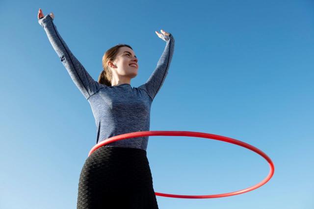 Frau trainiert mit Hula Hoop reifen