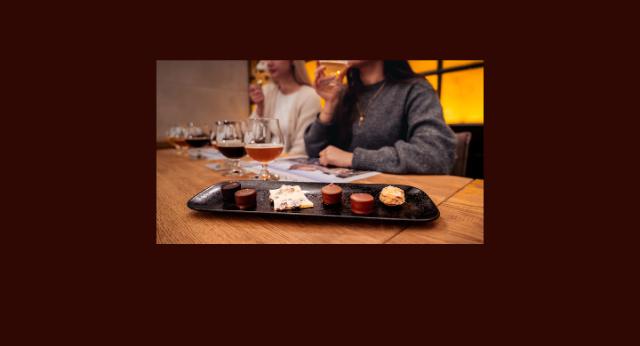 2 Gläser mit Bier und einige Schokopralinen auf einem Tablett