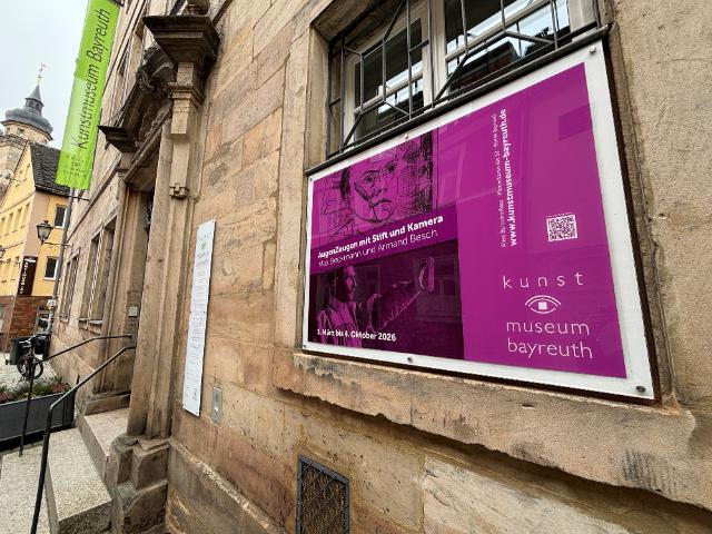 Blick auf das Kunstmuseum mit einem Plakat an der Wand zur Ausstellung Augenzeugen