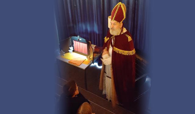 Mann im Nikolauskostüm liest vor