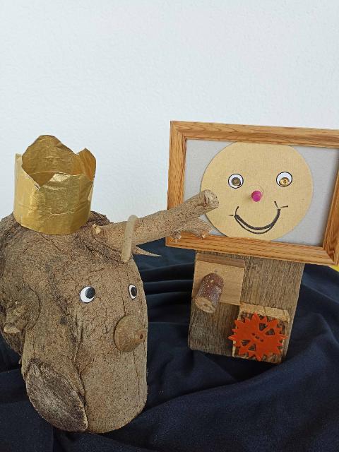 Ein Baumstamm mit Gesicht und Krone auf dem Kopf. 