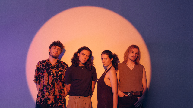 Mina Richman und Band vor lila Hintergrund, angestrahlt von einem Lichtkegel