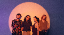 Mina Richman und Band vor lila Hintergrund, angestrahlt von einem Lichtkegel